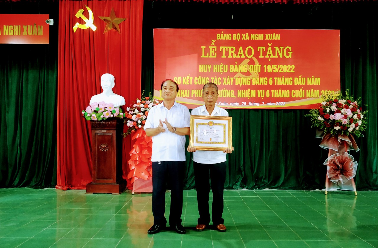 Đồng chí Lê Văn Dũng, phó bí thư huyện ủy trao và gắn huy hiệu 55 năm tuổi đảng cho đồng chí Hoàng Quốc Dũng